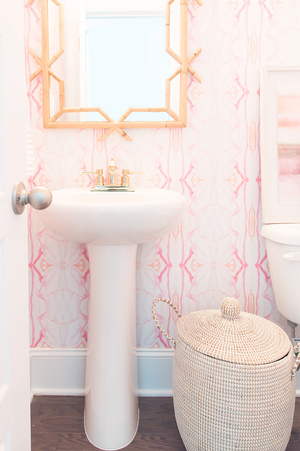 wallpaper installation, rattan mirror bathroom, pink powder room, pink wallpaper, pink painted wallpaper, artist wallpaper, pink powder room