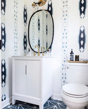 bathroom cement tiles, blue encaustic tiles, cement tile floor bathroom, navy white bathroom, navy white powder room, navy white wallpaper bath, oval vanity mirror charlotte interior designer